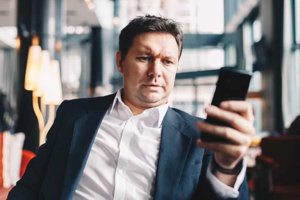 Good looking and fashionable young man sitting in a bar during a break from work, browsing the internet in his free time